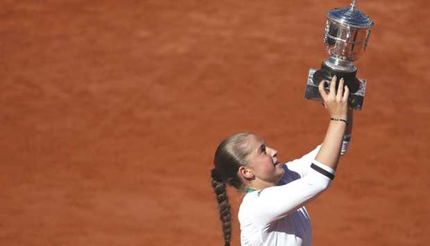 Latviau2019s Jelena Ostapenko celebrates with the trophy after winning the French Open final against Romaniau2019s Simona Halep (left, inset) at Roland Garros yesterday. (Reuters/AFP)