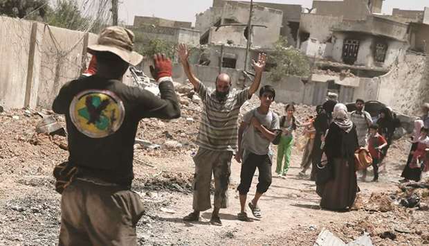 An Iraqi man (centre) is ordered to raise his hands for a check as civilians displaced by fighting between the Iraqi forces and Islamic State flee the Al Zanjili district in Mosul, yesterday.