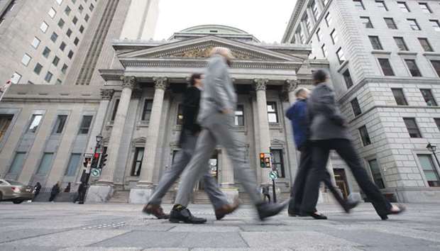 Pedestrians pass in front of the Bank of Montreal head office in Quebec, Canada. The soul of Canadau2019s oldest bank lies beneath the cobblestone streets of Old  Montreal in a vault protected by the guardians of history.