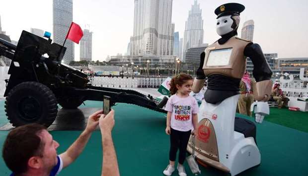 People take a picture with the world's first operational police robot near the Burj Khalifa