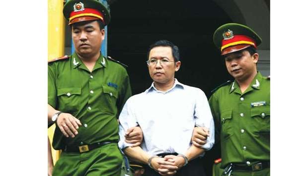 An August 10, 2011, file photo of French-Vietnamese blogger and lecturer Pham Minh Hoang being led out from the courtroom at the Ho Chi Minh City Peopleu2019s Court House after he was jailed for three years for attempted subversion.