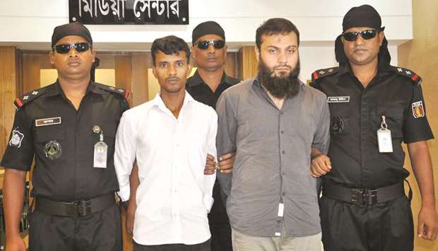 Imran Ahmed, second right, who runs a garment factory, and his driver Shamim Mia, second left, being presented to the media following their arrest in Dhaka yesterday.