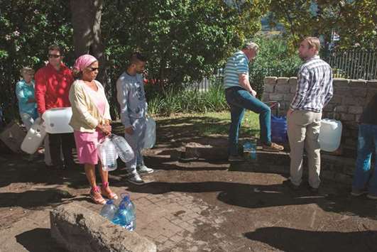 People queue up to collect drinking water from taps that are fed by a spring in Newlands in Cape Town.