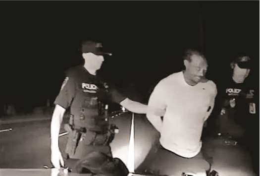 Tiger Woods is seen handcuffed and arrested by police officers in this still image from police dashcam video in Jupiter, Florida on Monday. (Reuters)