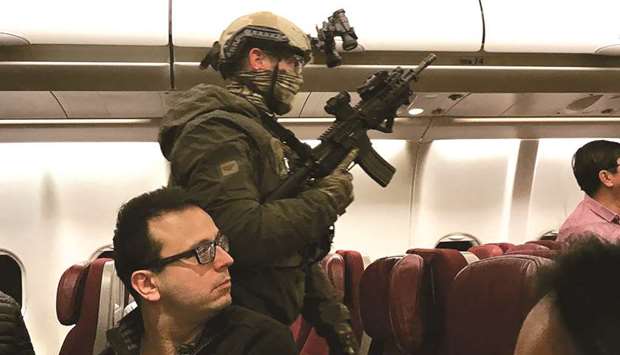 Heavily-armed police walking through Malaysia Airlines Flight MH128 to arrest a Sri Lankan man after the flight made an emergency landing in Melbourne.