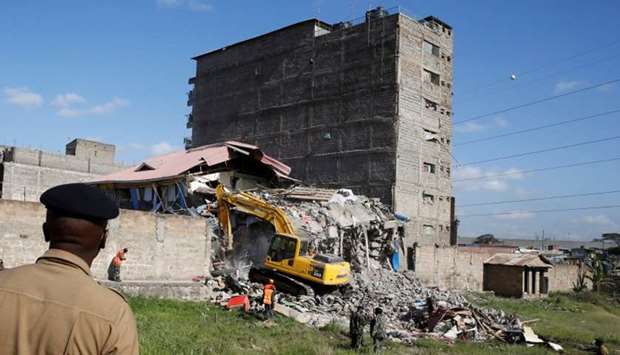 Security personnel look at the scene after a building collapsed in a residential area of Nairobi