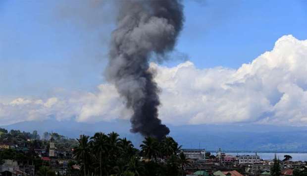 Smoke billows from a burning building in Marinaut village
