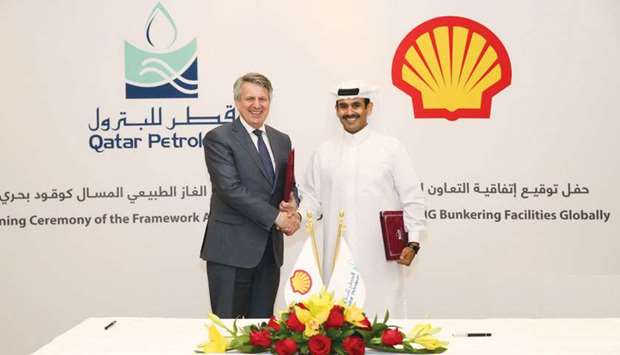 Al-Kaabi and van Beurden shake hands after concluding framework agreement to develop liquefied natural gas (LNG) marine fuelling, or bunkering, infrastructure at strategic shipping locations across the globe.