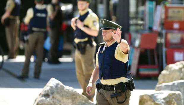 A police officer secures the entrance to the train station after a shooting in an S-Bahn station in Unterfoehring, a northeastern suburb of the Bavarian city of Munich.