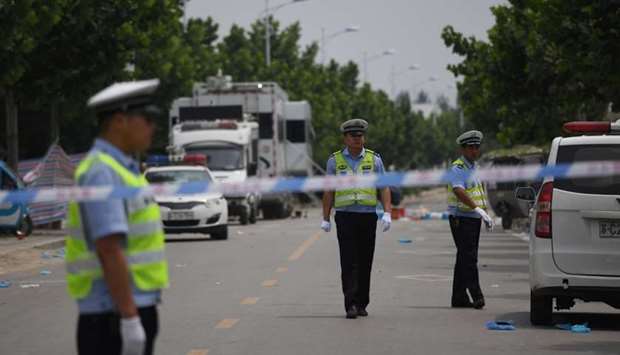 Police officers stand outside a kindergarten where an explosion killed 8 people and injured dozens a day earlier, in Fengxian.
