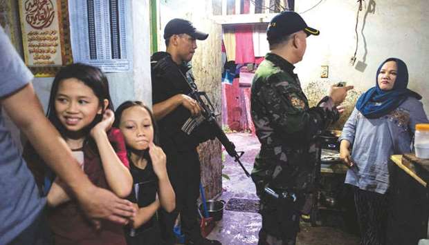 Members of Special Weapons and Tactics (SWAT) enter a house in a neighbourhood where evacuees from Marawi City are temporarily living in Iligan City.