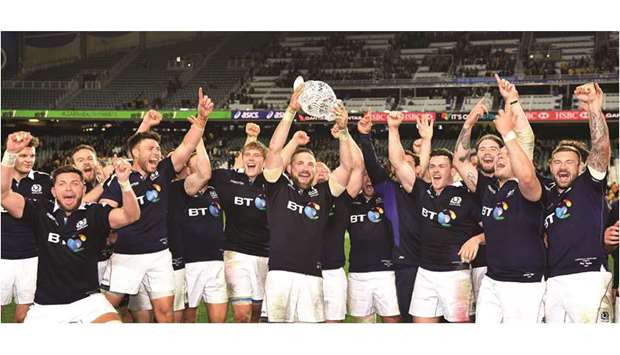 Scotlandu2019s captain John Barclay (C) holds the trophy as he celebrates with teammates after they defeated Australia in their Test match in Sydney yesterday. (AFP)