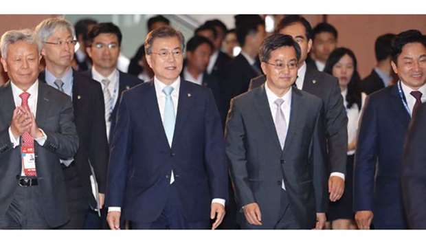 South Korean President Moon Jae-in and Asian Infrastructure Investment Bank president Jin Liqun (left) arrive at an opening ceremony for the 2nd annual meeting of AIIB, in Jeju, South Korea, yesterday.