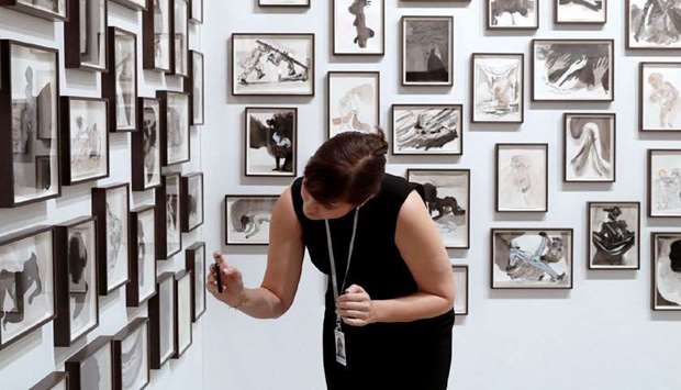 A woman takes pictures from Notes Drawn by a Negress After a Long Absence (2016) by US artist Kara Walker during the Art Basel.