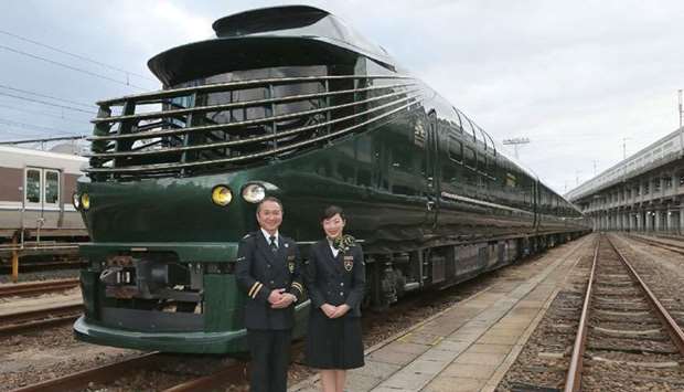 Members of the crew pose with the Twilight Express Mizukaze during its press preview in Osaka.
