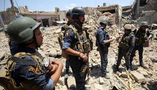 Iraqi forces stand amid the rubble of a building as they advance towards Mosul's Old City on Sunday.