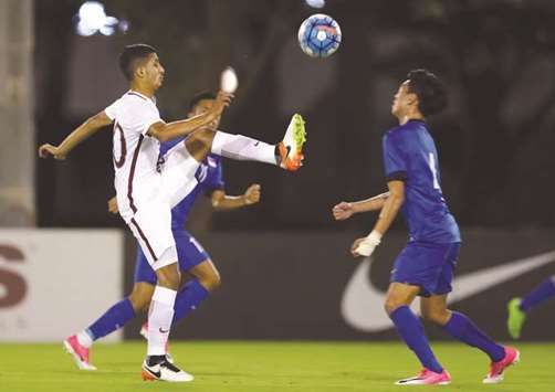 Action from the friendly match between Qatar (in white) and Singapore (in blue) at Aspire Zone.