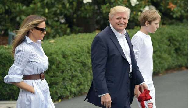 President Donald Trump, First Lady Melania Trump, and son Barron make their way to board Marine One on the South Lawn of the White House on their way to Camp David.