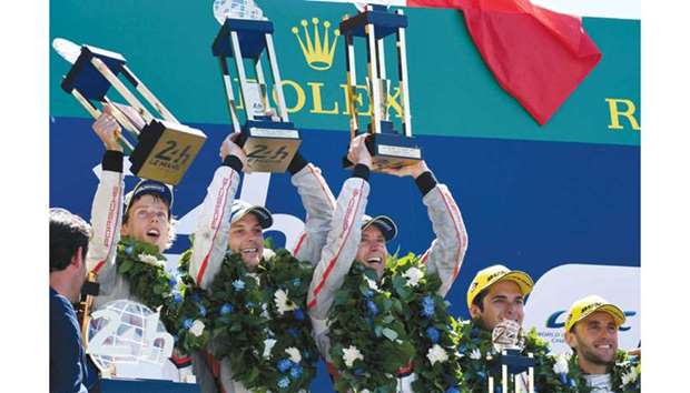 (From L to R) New Zealandu2019s driver Brendon Hartley, New Zealandu2019s driver Earl Bamber and Germanyu2019s driver Timo Bernhard celebrate on the podium after winning the 85th Le Mans 24-hours endurance race with their Porsche 919 Hybrid No. 2 yesterday in Le Mans, western France. (AFP)