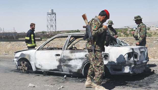 Afghan security forces inspect the exterior of a car after a suicide bomb blast in Gardez, Paktia Province, Afghanistan, yesterday.