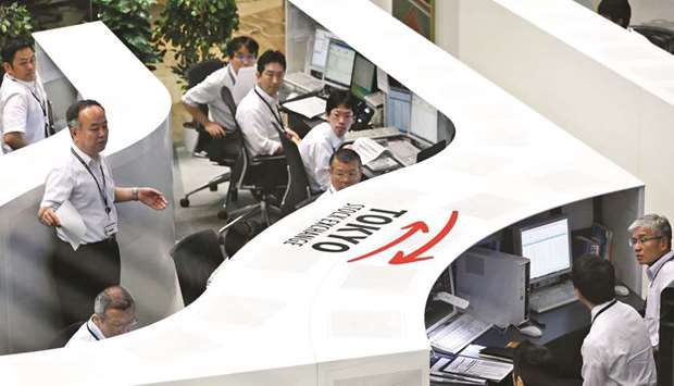 Employees work at the Tokyo Stock Exchange. The Nikkei 225 closed up 0.6% to 20,067.75 points yesterday.