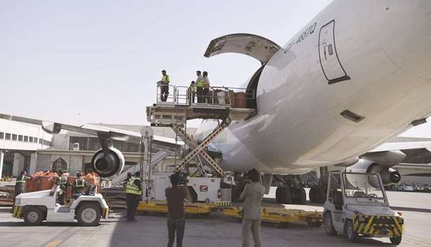 Afghan airport workers load the first cargo plane bound for India on June 19 in Kabul.
