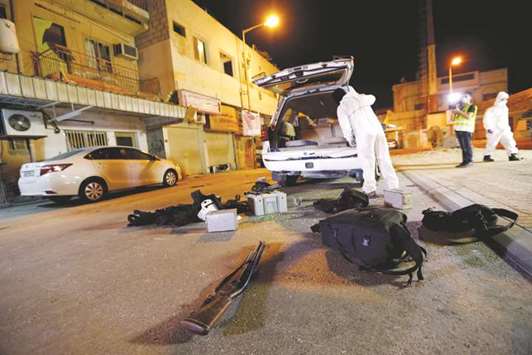 Crime scene personnel are seen gathering evidence at the site of  a blast  in the village of Diraz, yesterday.
