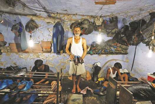 A shoemaker poses for a picture in an underground workshop in Agra, India.