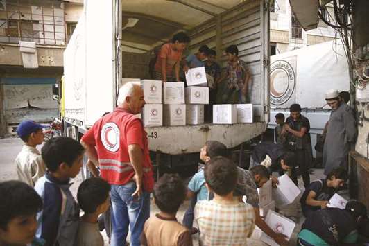 People unload parcels of humanitarian aid in the rebel-held Harasta area, in the eastern Damascus suburb of Ghouta, yesterday.