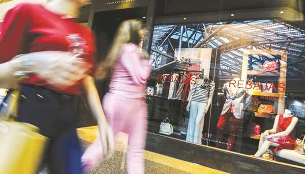 Shoppers walk past a clothing store at a mall in Caracas. Venezuela is stricken by poverty and political violence, but a rich minority act as if they were untouched by the crisis.