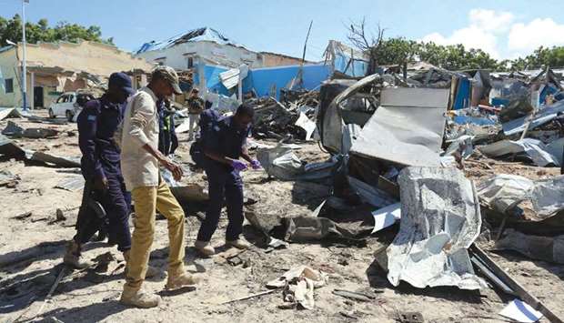 Somali policemen assess the scene of an attack on a government building in Mogadishu.