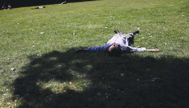 A man rests in a park during a lunch break on a sunny day in central London yesterday.