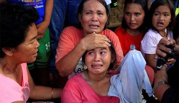 Residents weep while waiting for a vehicle after Islamist militants, who had holed up in a primary school, retreated after a gunbattle with troops in Pigcawayan on Wednesday.