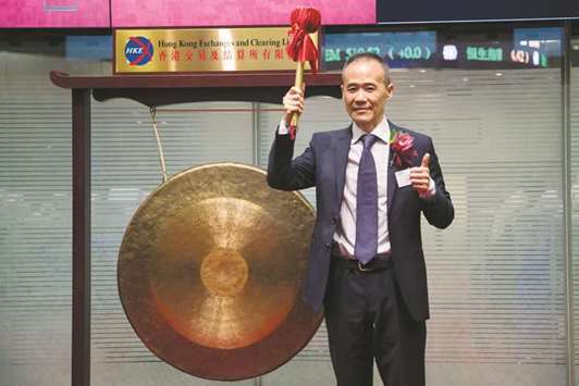 China Vankeu2019s chairman Wang Shi reacts after hitting the gong during the debut of his company at the Hong Kong Stock Exchange on June 25, 2014. Wang, who built the company into the countryu2019s biggest developer after founding it 33 years ago, stepped down as chairman after an ownership tussle that ended with a state entity becoming its biggest investor.