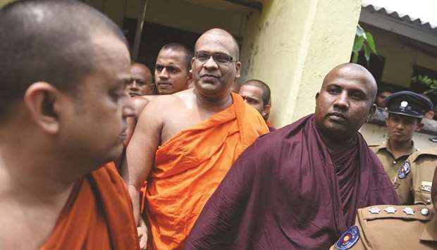 Galagodaatte Gnanasara, centre, arrives at a court in Colombo yesterday, to surrender in response to a warrant for his arrest.