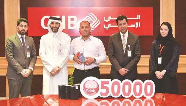 QIIB officials during the awards ceremony of the first winners of its u2018alternative channelsu2019 promotion.