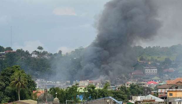 Smoke billows from houses after aerial bombings by Philippine Airforce planes on militants