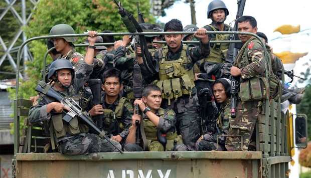 Members of the Philippine police special action force ride in an army truck on their way to Marawi