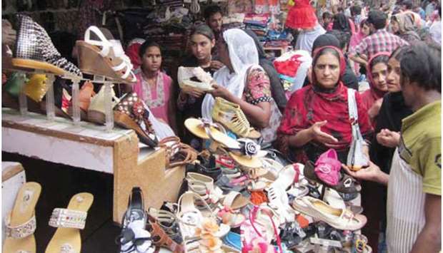 Women buy sandals at market ahead of Eid al-Fitr in Lahore.