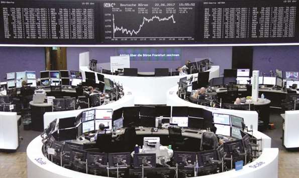 Traders work in front of the DAX board at the Frankfurt Stock Exchange yesterday. The DAX ended the day with gains of 0.2% at 12,794.00 points.