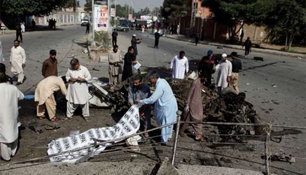 Police and rescue officials cover a body after a blast in Quetta on Friday.