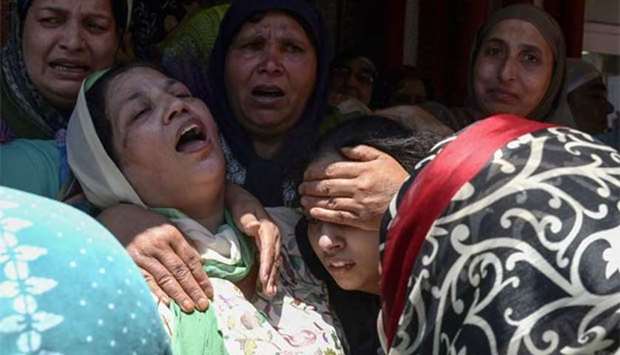 The wife and daughter of police officer Mohammad Ayub Pandith mourn at his home in Srinagar on Friday.