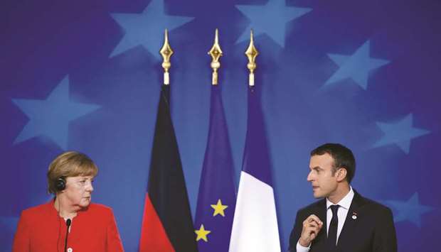 German Chancellor Angela Merkel and French President Emmanuel Macron addresses a joint news conference at the EU summit in Brussels yesterday. EU leaders tackle the thorny topic of globalisation at a summit yesterday with deep divisions between proponents of free markets and others seeking more protections, most notably France.
