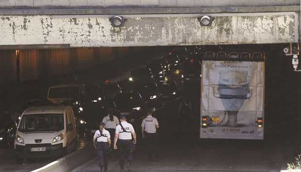 Police officers are seen near the bus stuck under the Alexandre III bridge in Paris.
