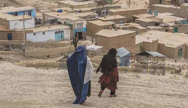 Nawzi Fakiri, left, and Afghan resident Anissa Azimi, walk through Zanabad on the outskirts of Kabul.