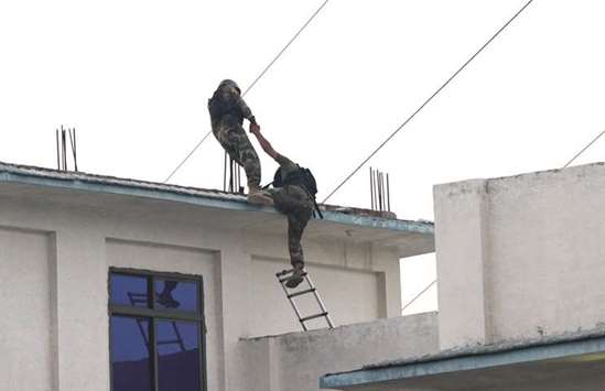 Pakistani army soldiers climb on a rooftop during a search operation against militants on the outskirts of Peshawar yesterday. Multiple blasts and a gun attack killed 57 people and wounded at least 170 in three Pakistani cities on the last Friday of Ramadan, as officials warned the toll could rise.
