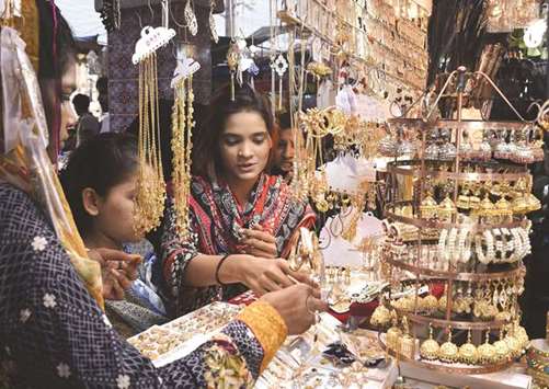 In this picture taken on Friday Pakistani women look at jewellery at a shop, ahead of Eid al-Fitr in Karachi.