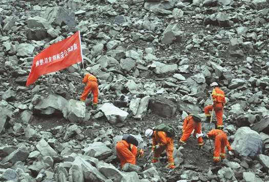 Rescue workers search for survivors at the site of a landslide that occurred in Xinmo village, Mao county, Sichuan province.