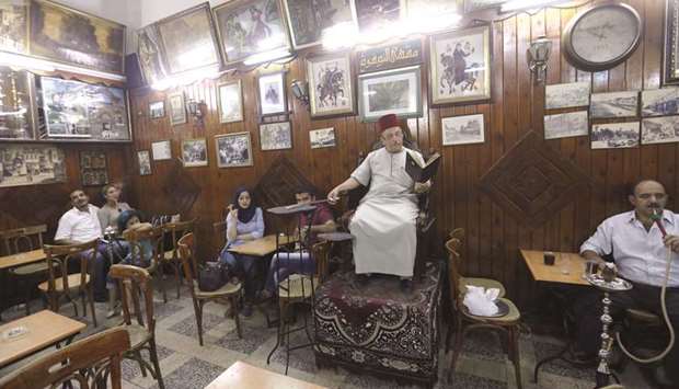 Ahmad al-Lahham, a Syrian storyteller, reads from his storybook in a Damascus coffee house.