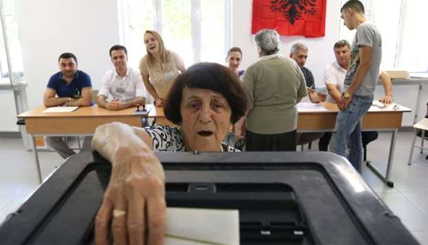 A wpman casts her ballot at a polling station in Tirana